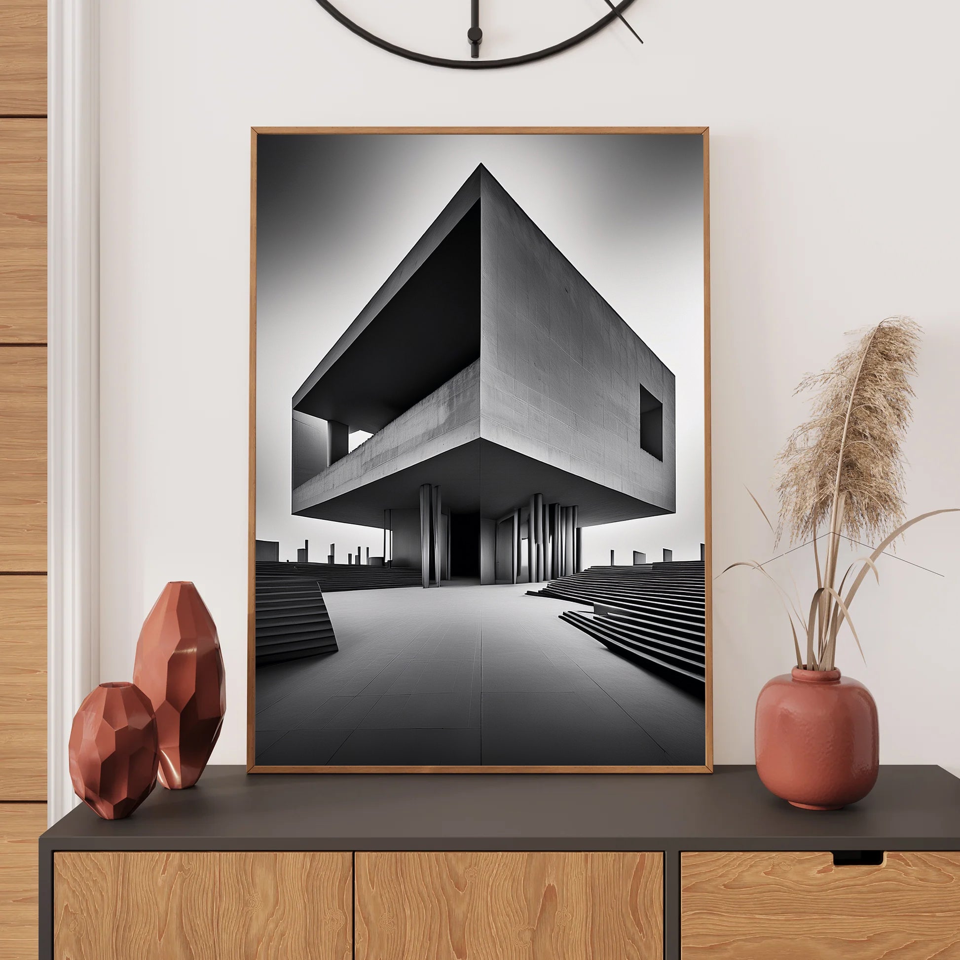Framed black and white architectural artwork on a wall above a wooden console table with decorative items.
