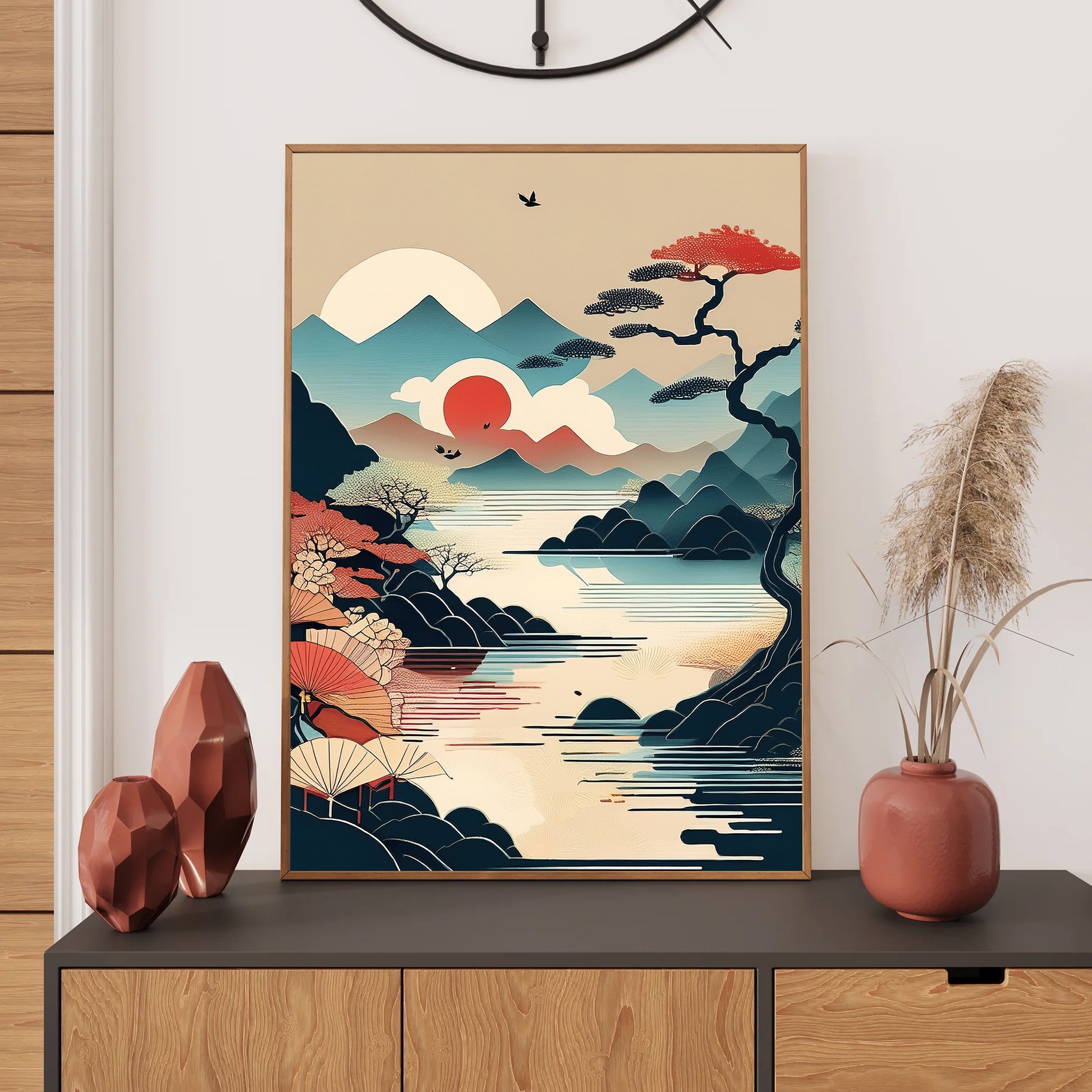 Framed artwork of a mountain landscape with a sun and trees on a wall above a wooden cabinet.
