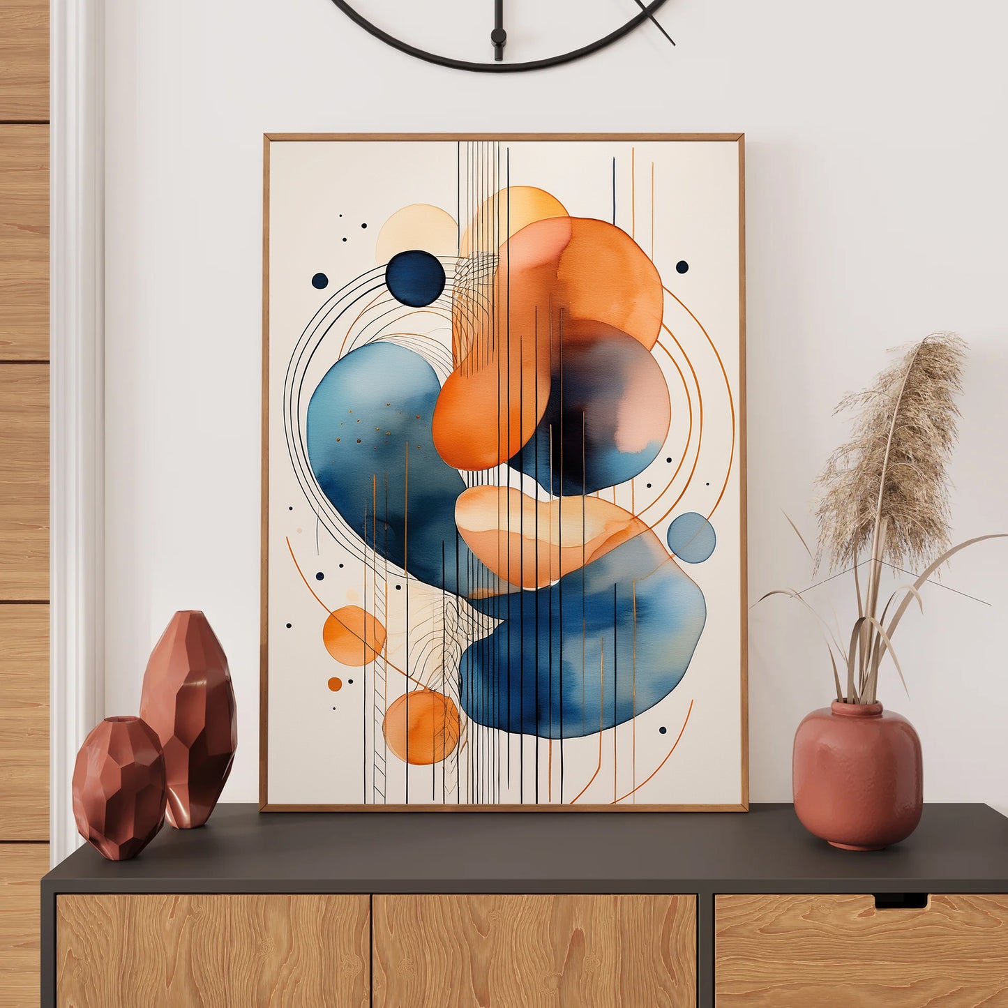 Abstract art piece with orange and blue circles on a wall above a wooden cabinet.